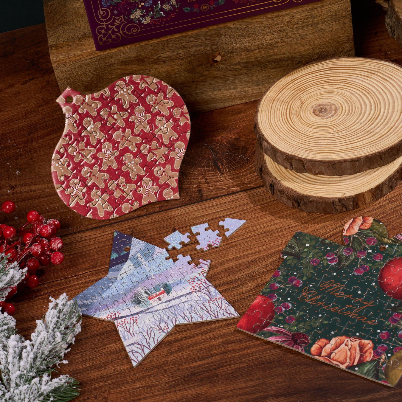 Decorative jigsaw puzzles with floral patterns on a wooden surface with Christmas decorations.