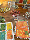 Jigsaw puzzles on a wooden table with book covers as puzzle pieces.