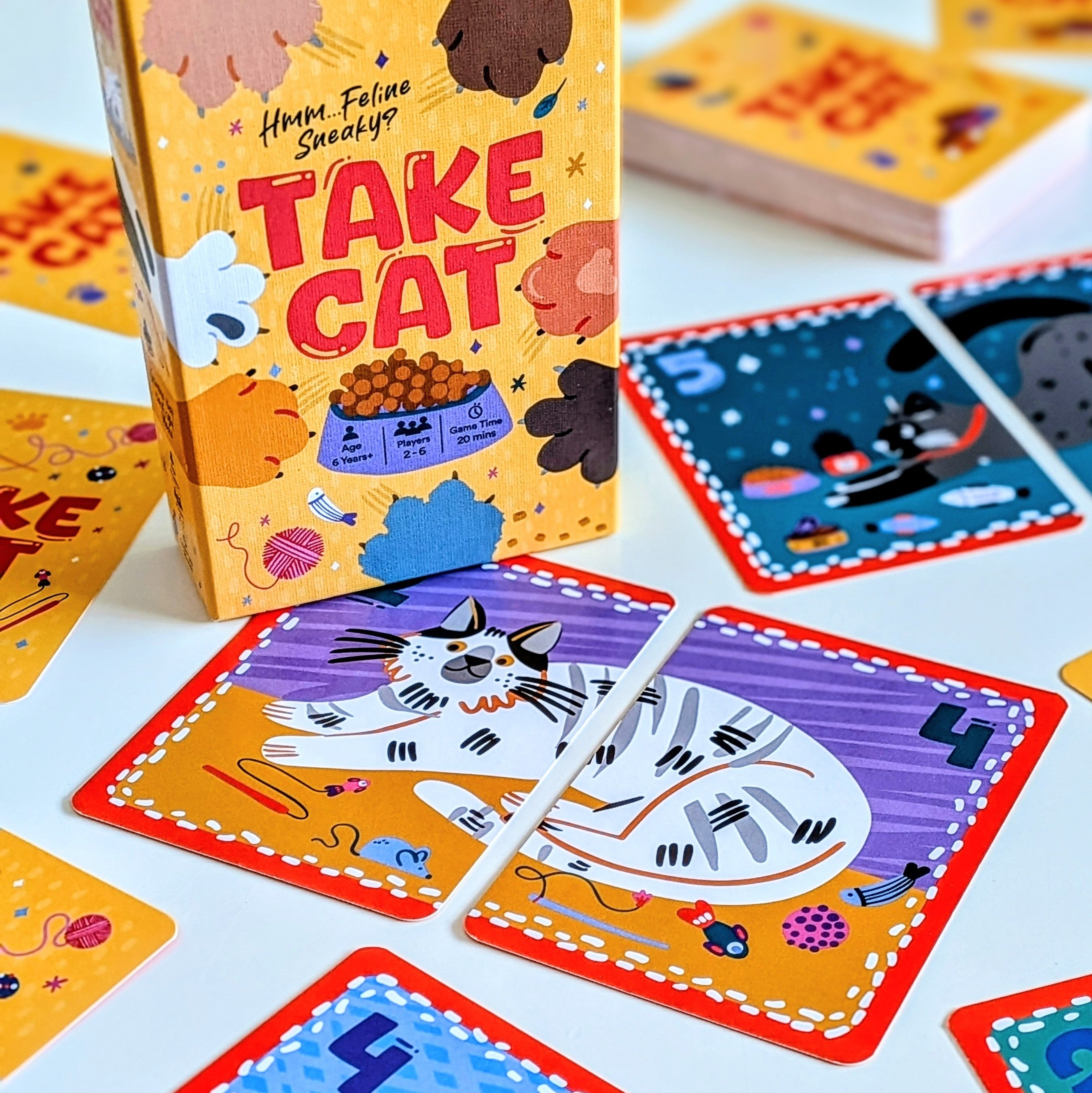 Card game 'Take Cat' with colourful cards and packaging on a white background