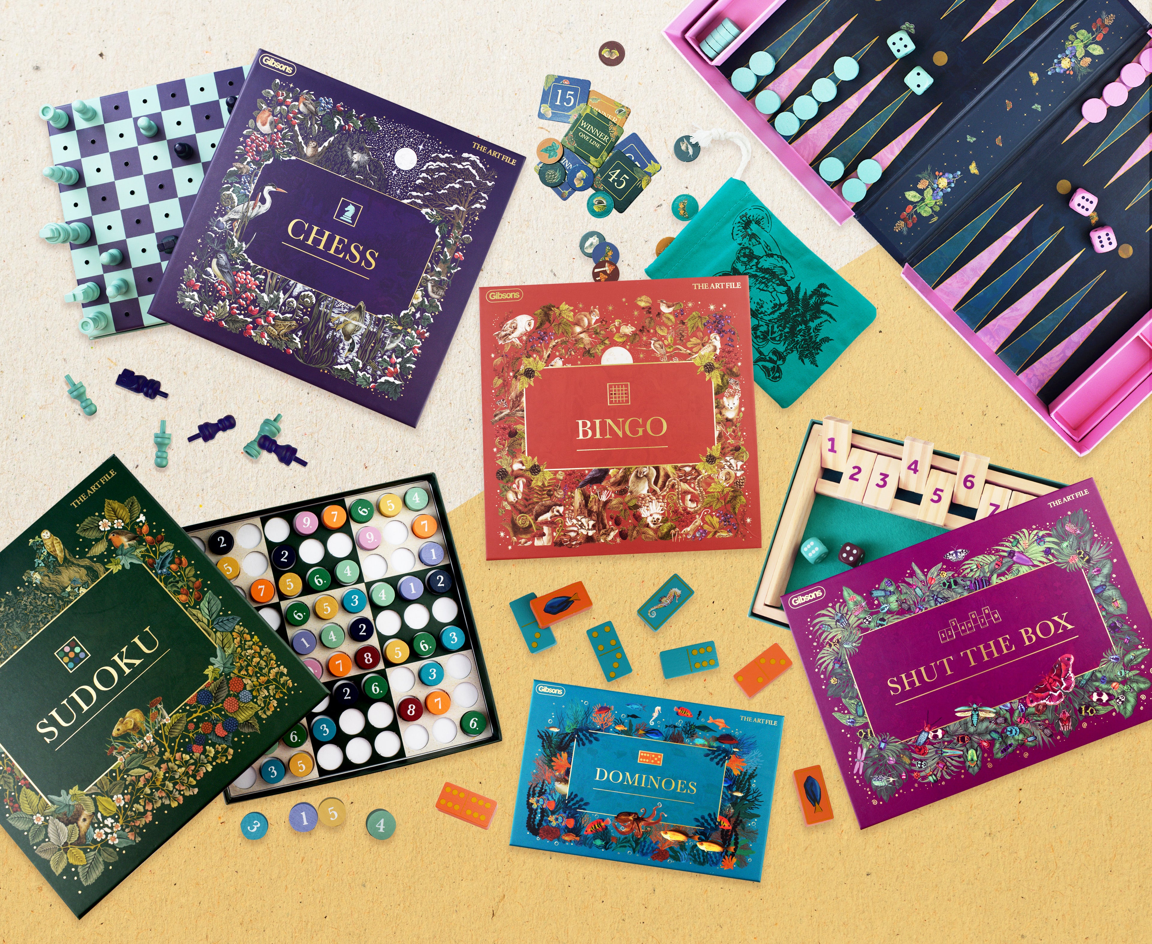Collection of board games including chess, bingo, sudoku, dominoes, and shut the box on a beige surface.