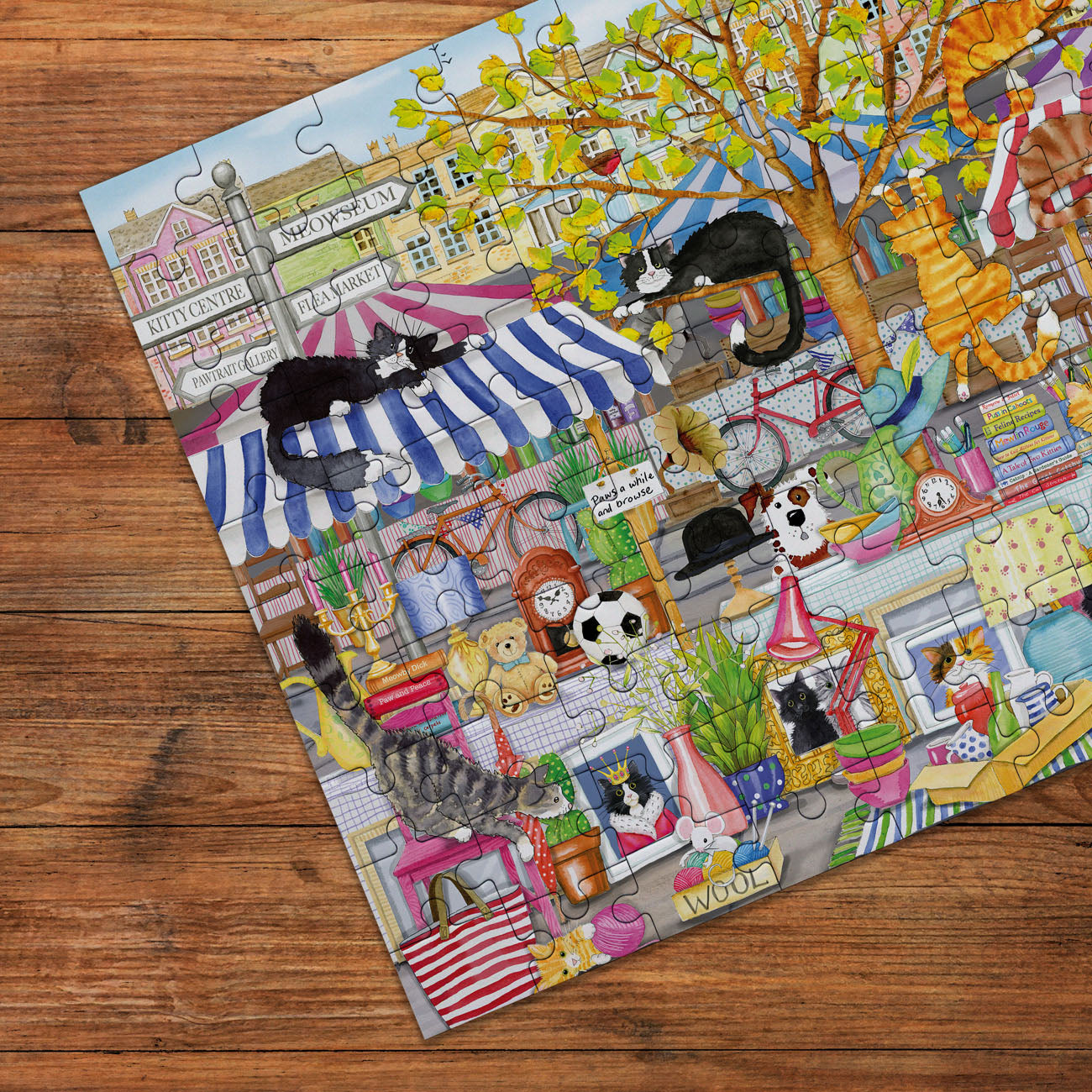 Colorful puzzle with cats in various settings on a wooden surface