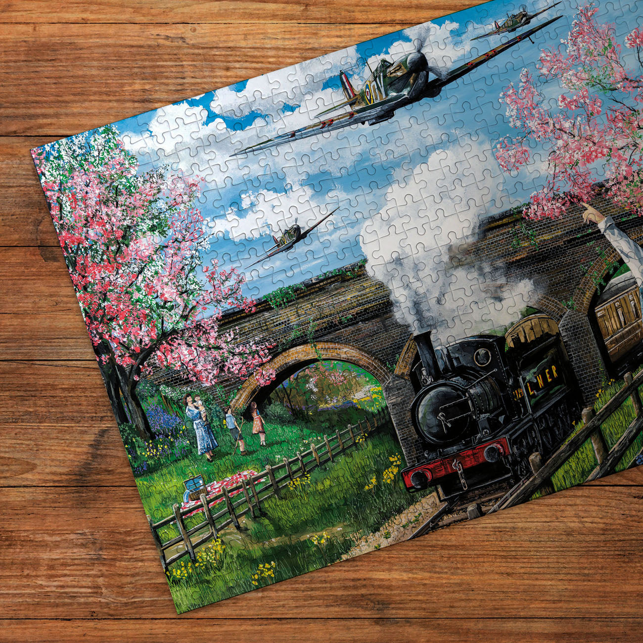 Jigsaw puzzle with a scenic design of a steam train and cherry blossoms on a wooden surface