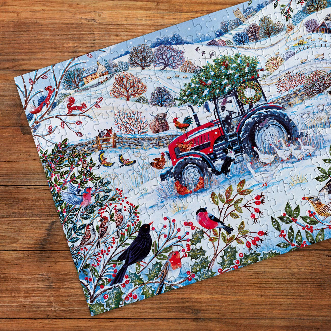 Jigsaw puzzle with a winter scene featuring a red tractor on a wooden surface