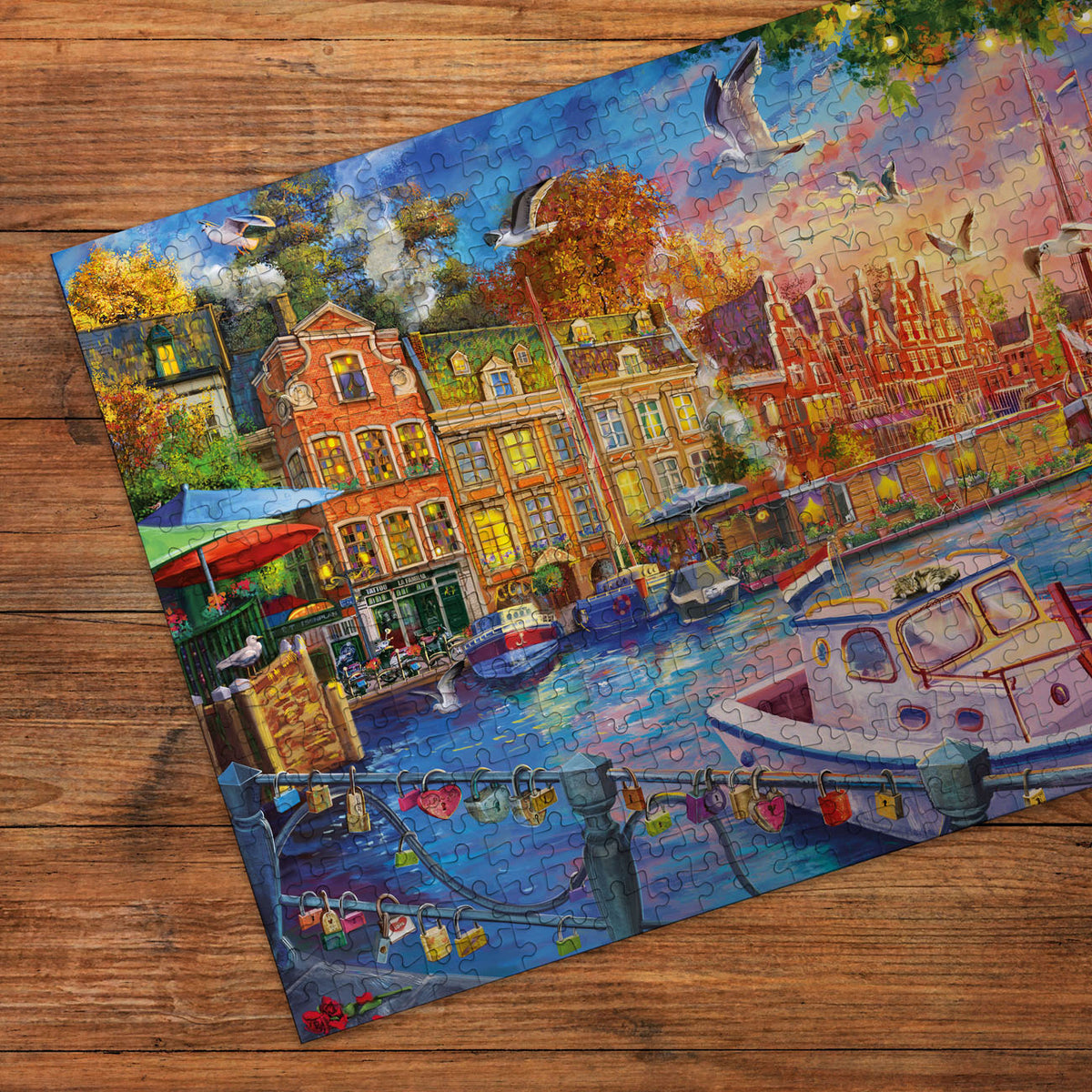 Colourful puzzle of a canal scene with boats and buildings on a wooden surface