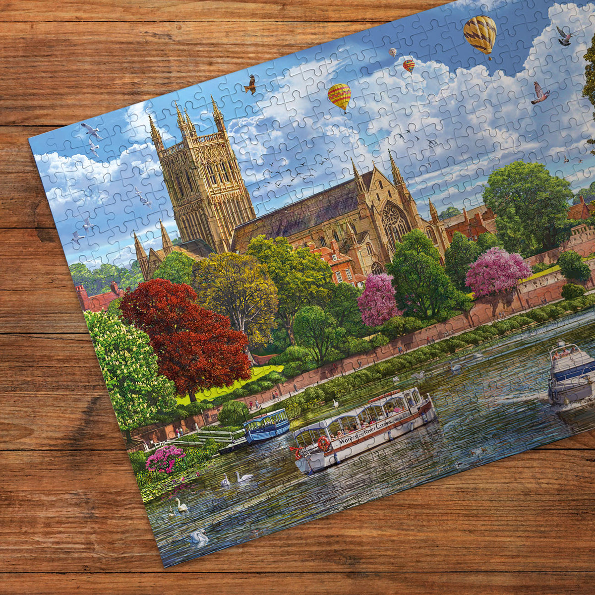 Jigsaw puzzle with a scenic layout of a cathedral and river on a wooden surface