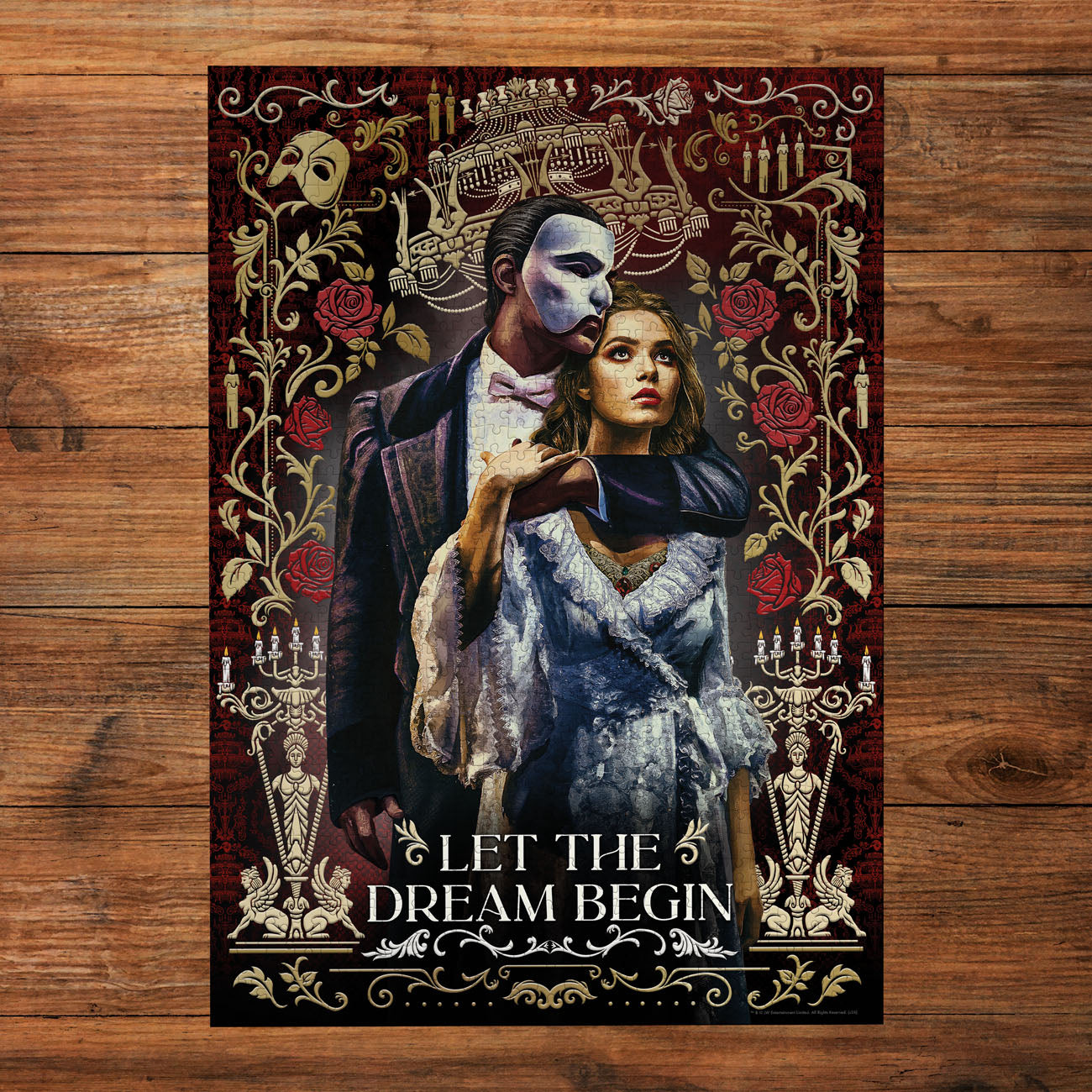 Poster of a man and woman with text 'Let the Dream Begin' on a wooden surface
