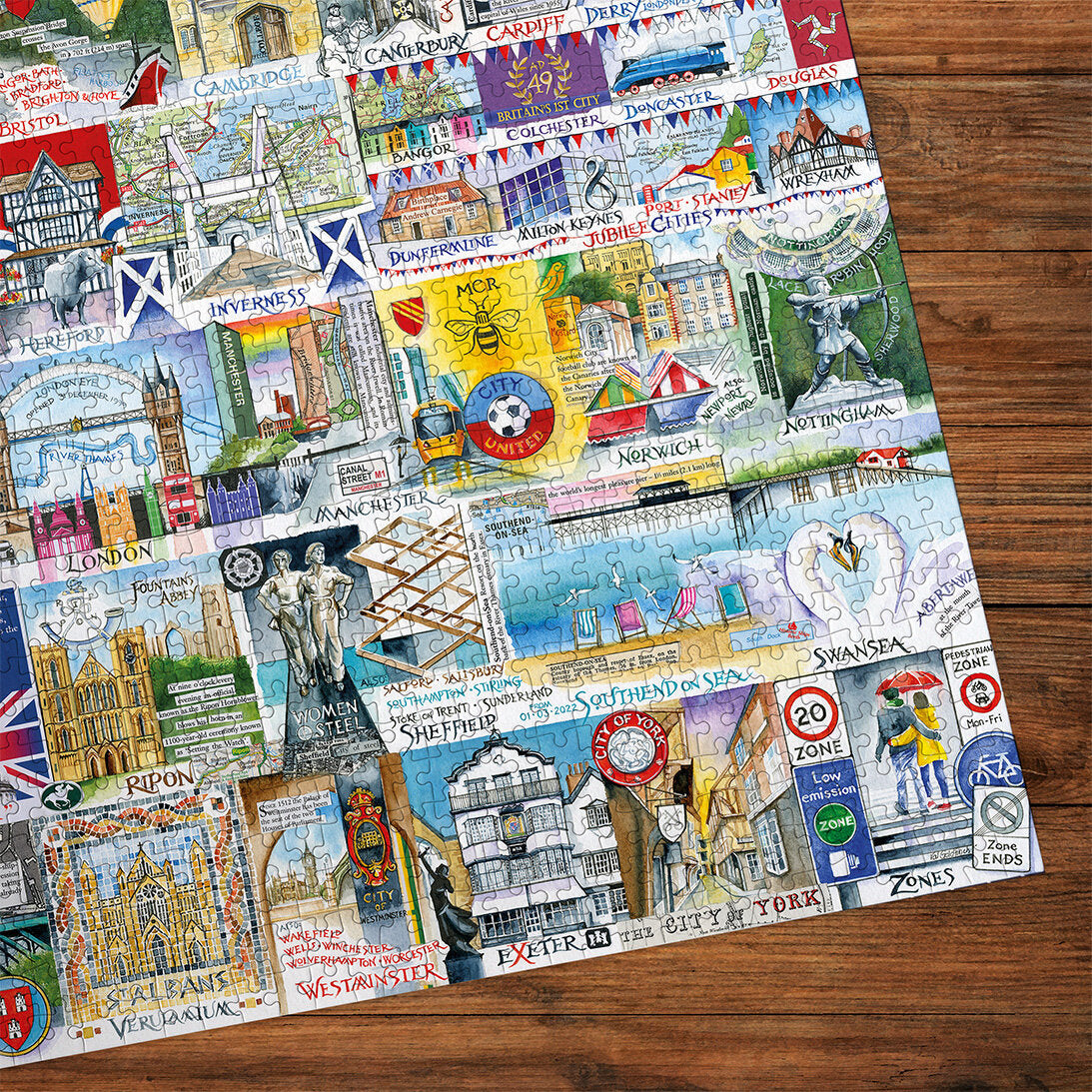 Gibsons Bright Lights & Big Cities Extra Large 500 Piece Jigsaw Puzzle made up detail on wooden table