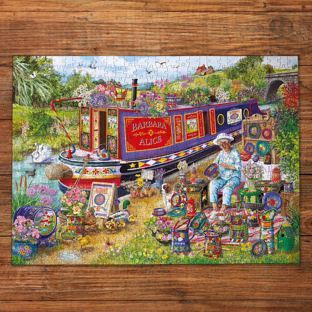 Colorful puzzle with a scenic design featuring a narrowboat and garden on a wooden surface.