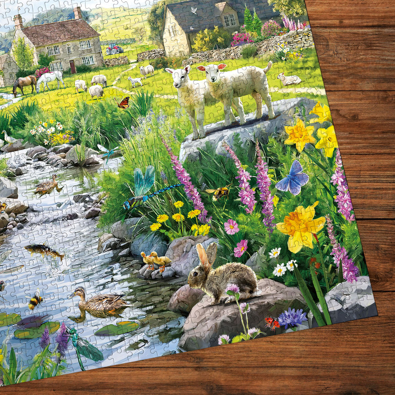 Jigsaw puzzle with a scenic landscape featuring animals and flowers on a wooden surface.