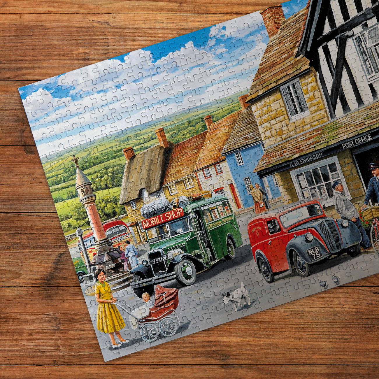 Jigsaw puzzle with a village scene on a wooden surface