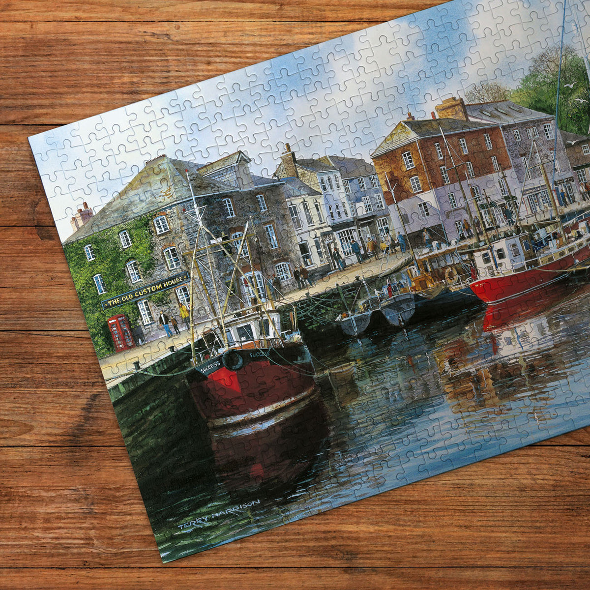 Jigsaw puzzle with a harbor scene on a wooden surface
