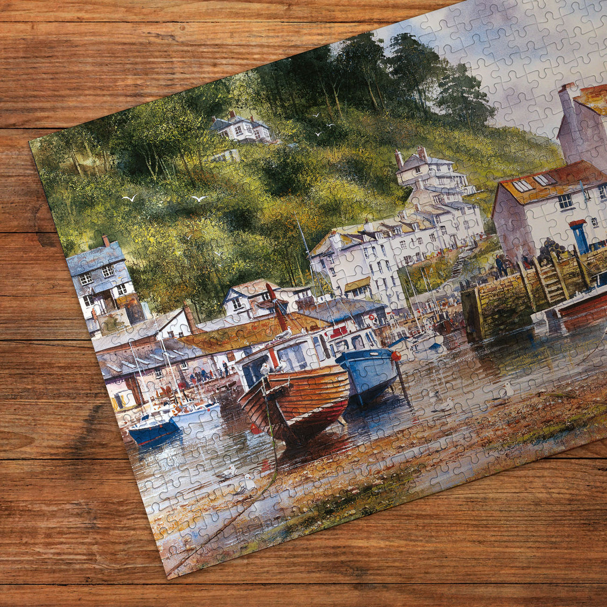 Jigsaw puzzle of a coastal scene with houses and boats on a wooden surface