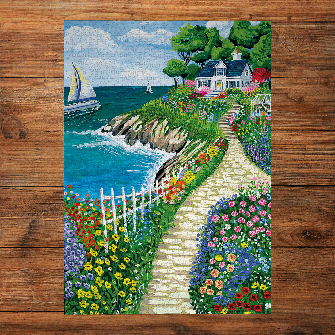 Gibsons Call of the Coast 3x500 Multi-box Gift Set Jigsaw Puzzles, Cliffside Cottage made up on wooden table
