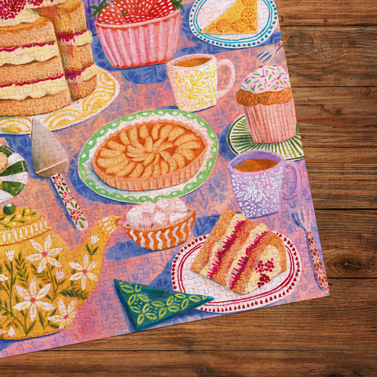 Colourful puzzle with images of cakes, pies, and tea cups on a wooden surface