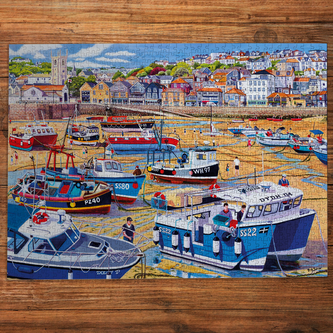 Jigsaw puzzle of a harbor scene with boats and buildings on a wooden surface