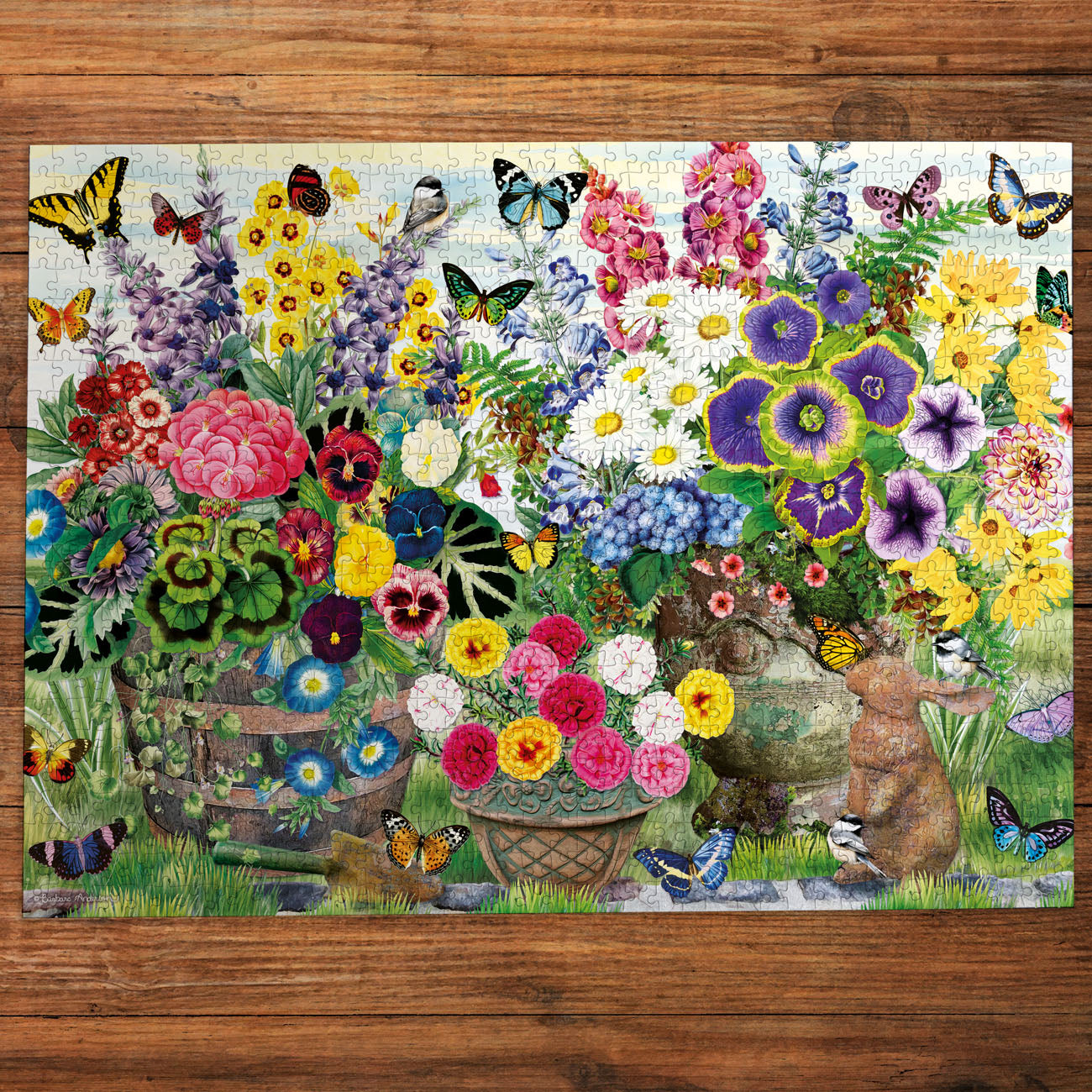 Colorful floral arrangement with butterflies and a rabbit on a wooden surface