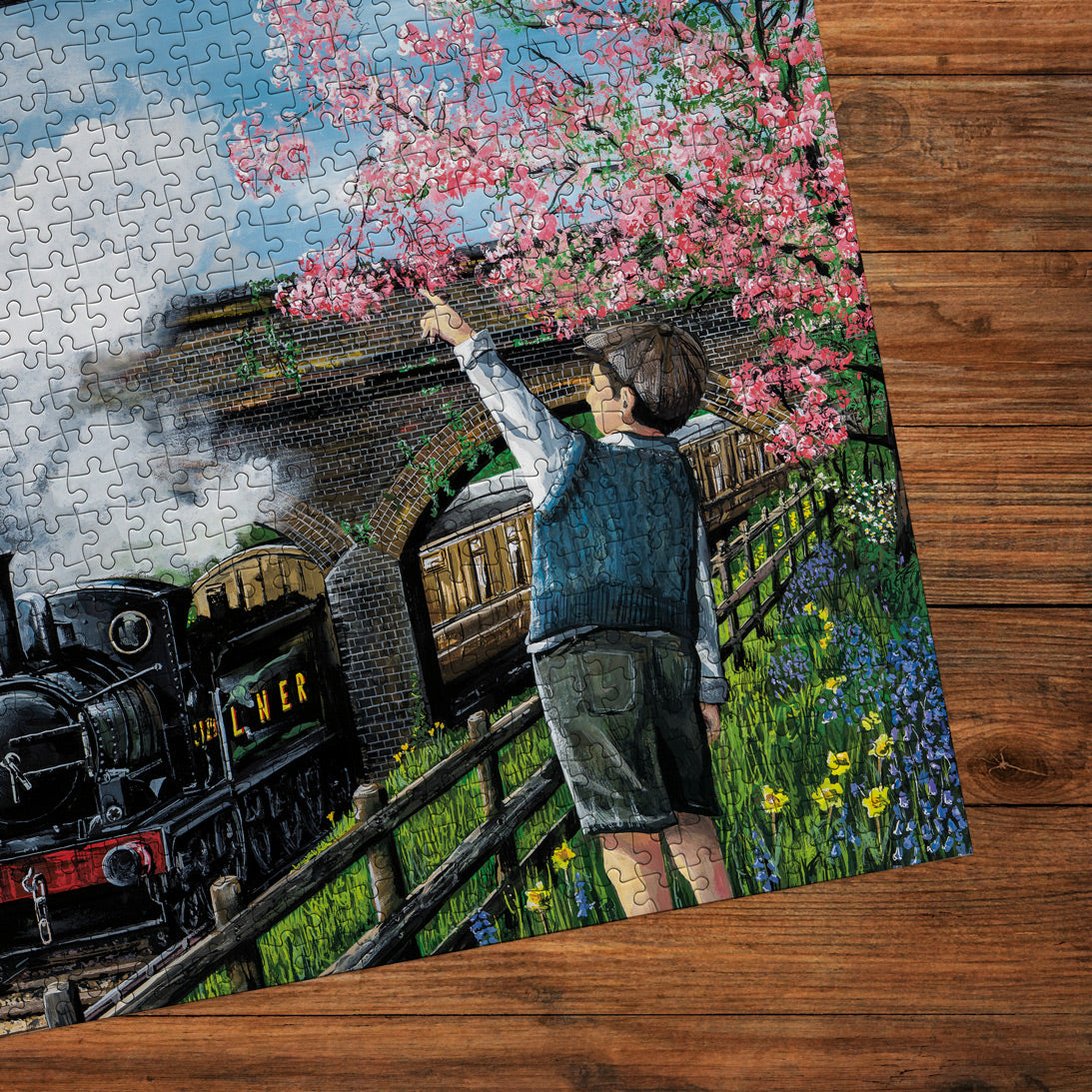 Jigsaw puzzle with a scenic design of a boy and train on a wooden surface