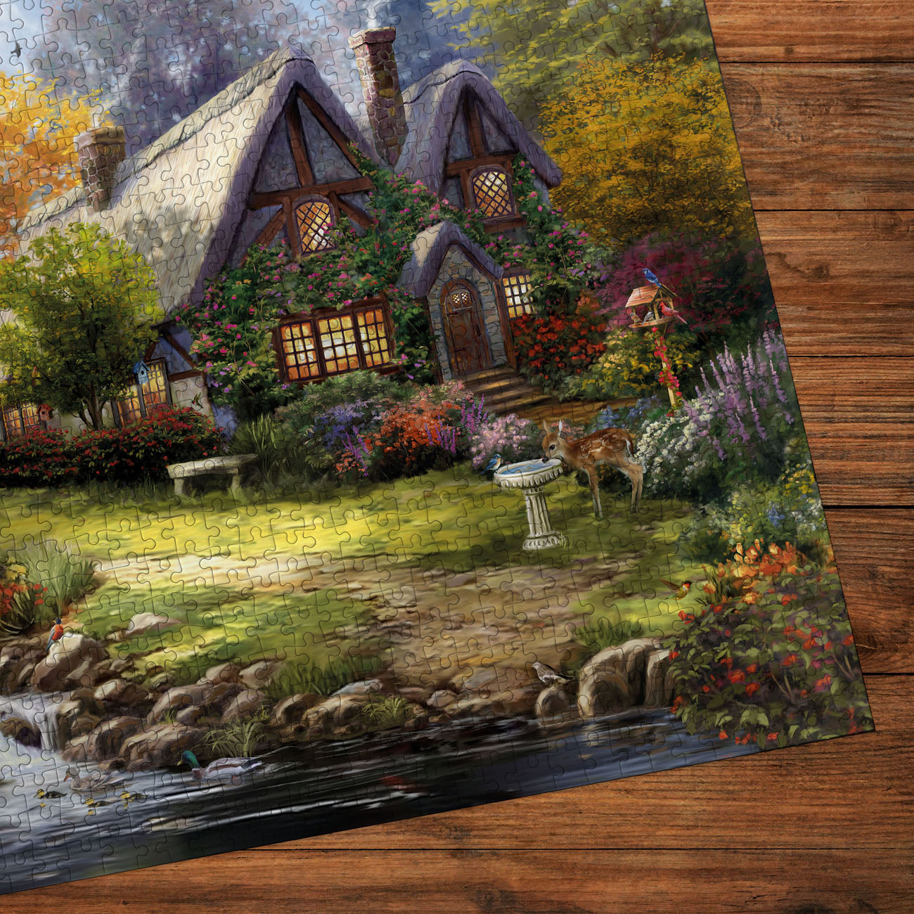 Painting of a quaint cottage with a garden on a wooden surface