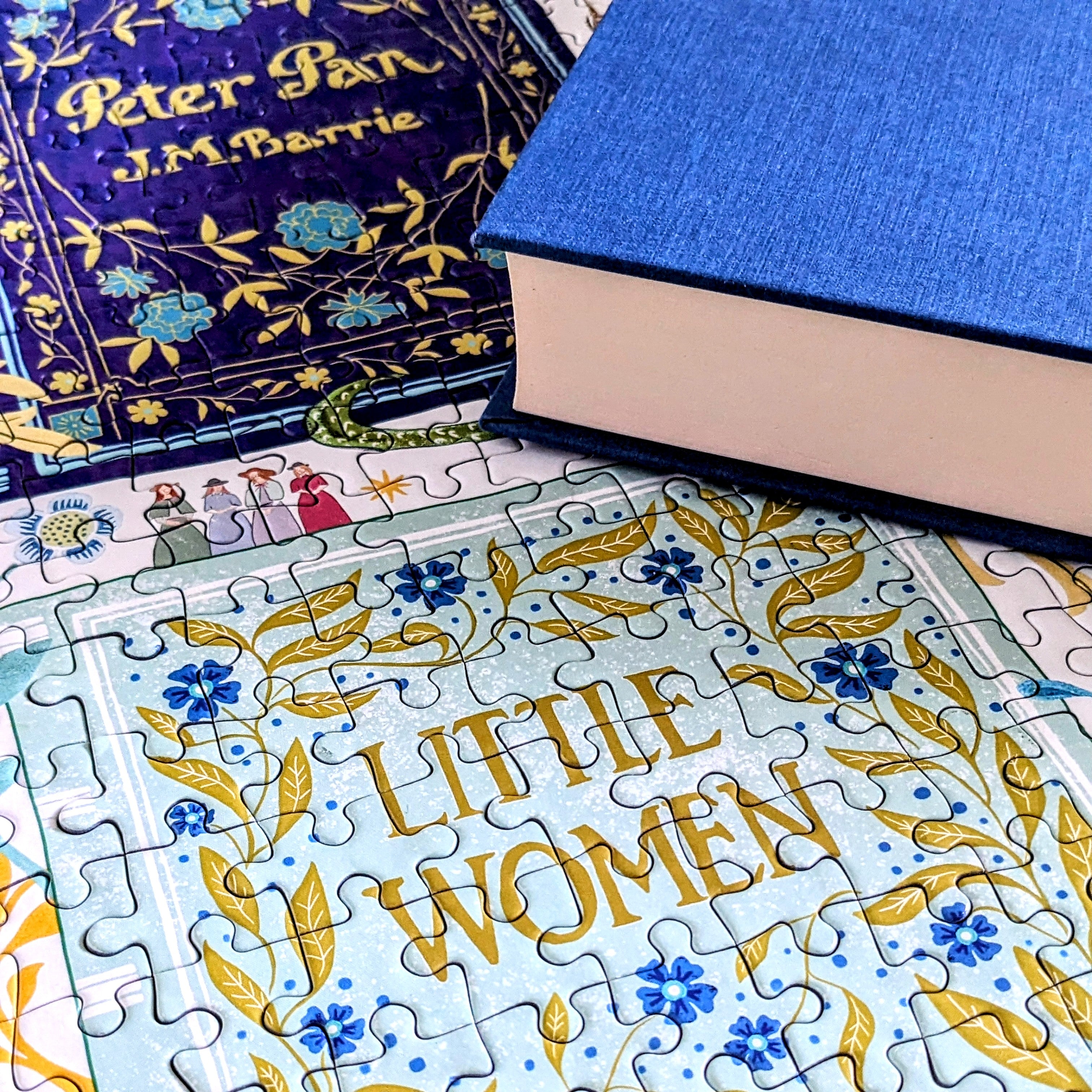 Jigsaw puzzle with 'Little Women' design, books in the background