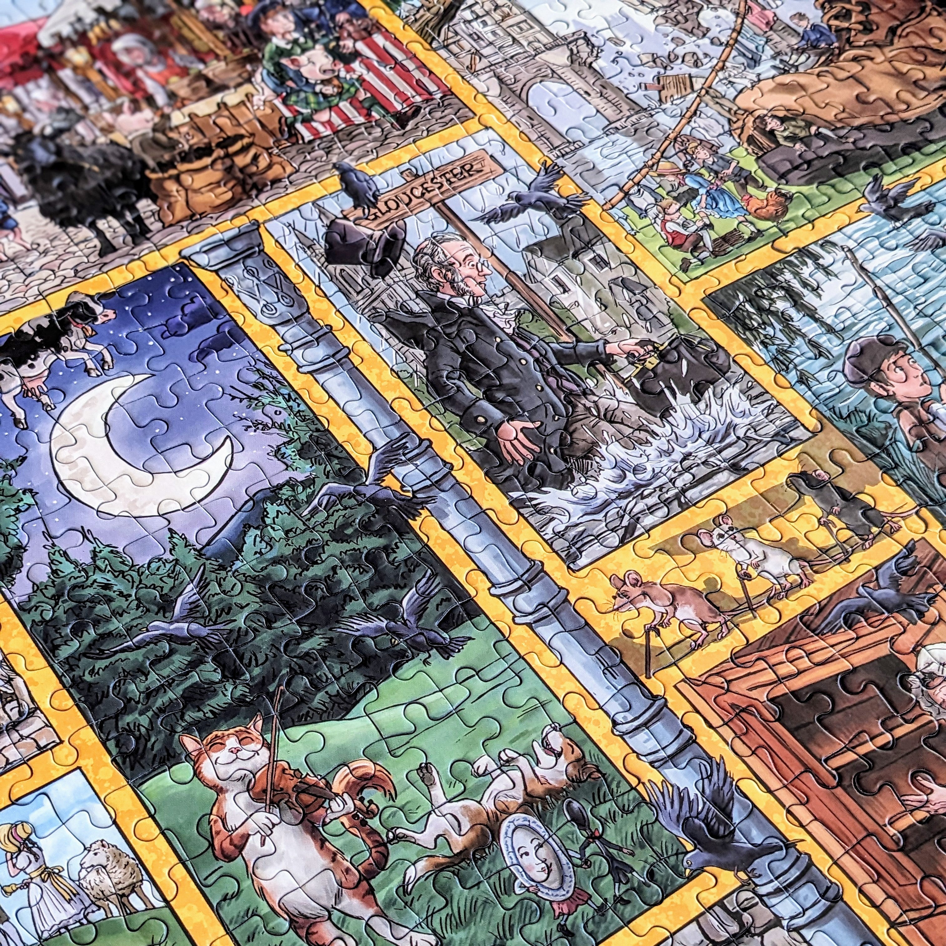 A close-up of a completed jigsaw puzzle featuring a detailed illustrated scene with multiple fantasy and historical panels divided by yellow borders. The artwork includes a crescent moon, trees, figures, animals, and architectural details in many colors.