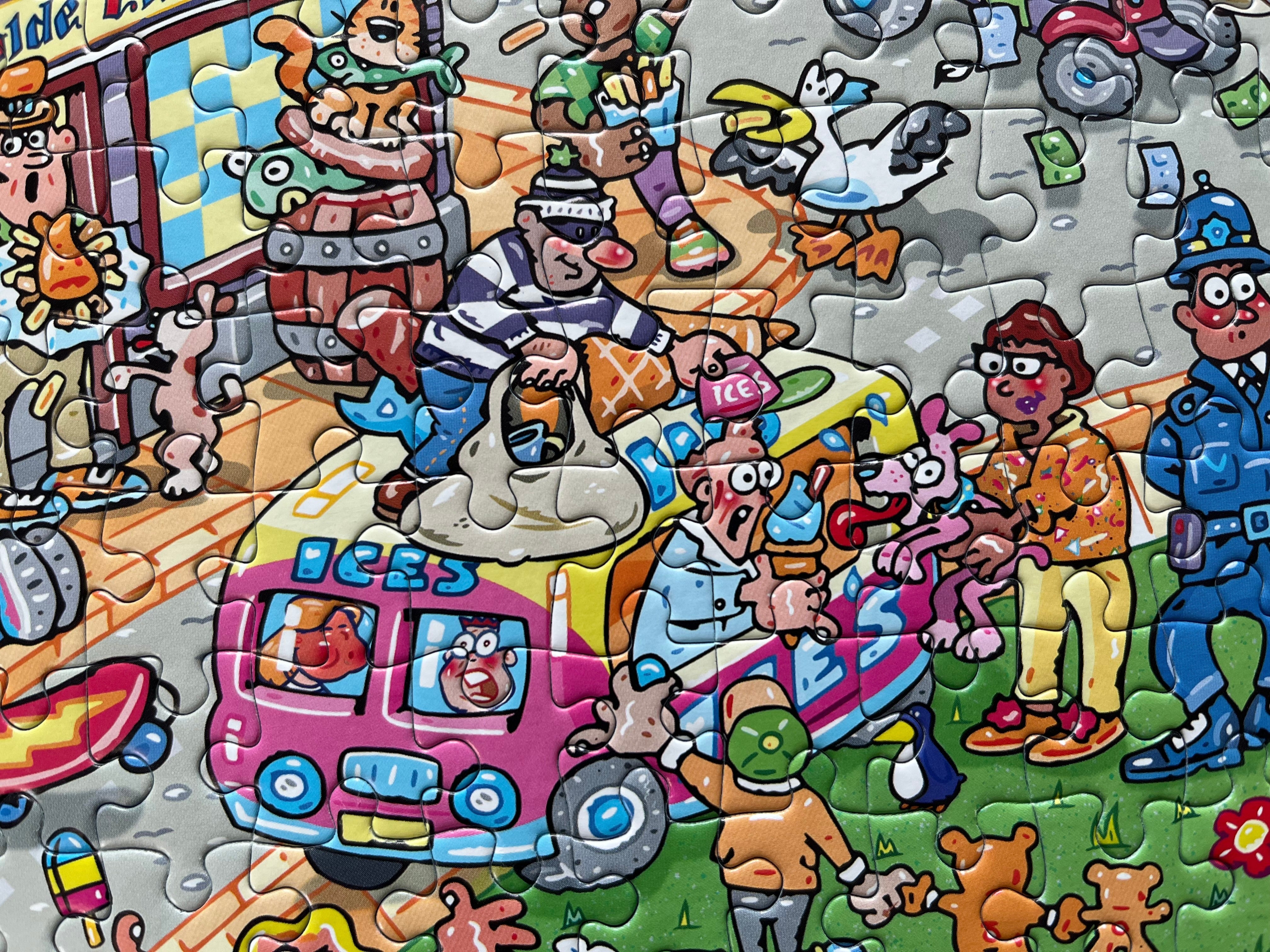 A colourful cartoon-style jigsaw puzzle showing a busy street scene with a pink bus, people, animals, a police officer, and various playful elements.