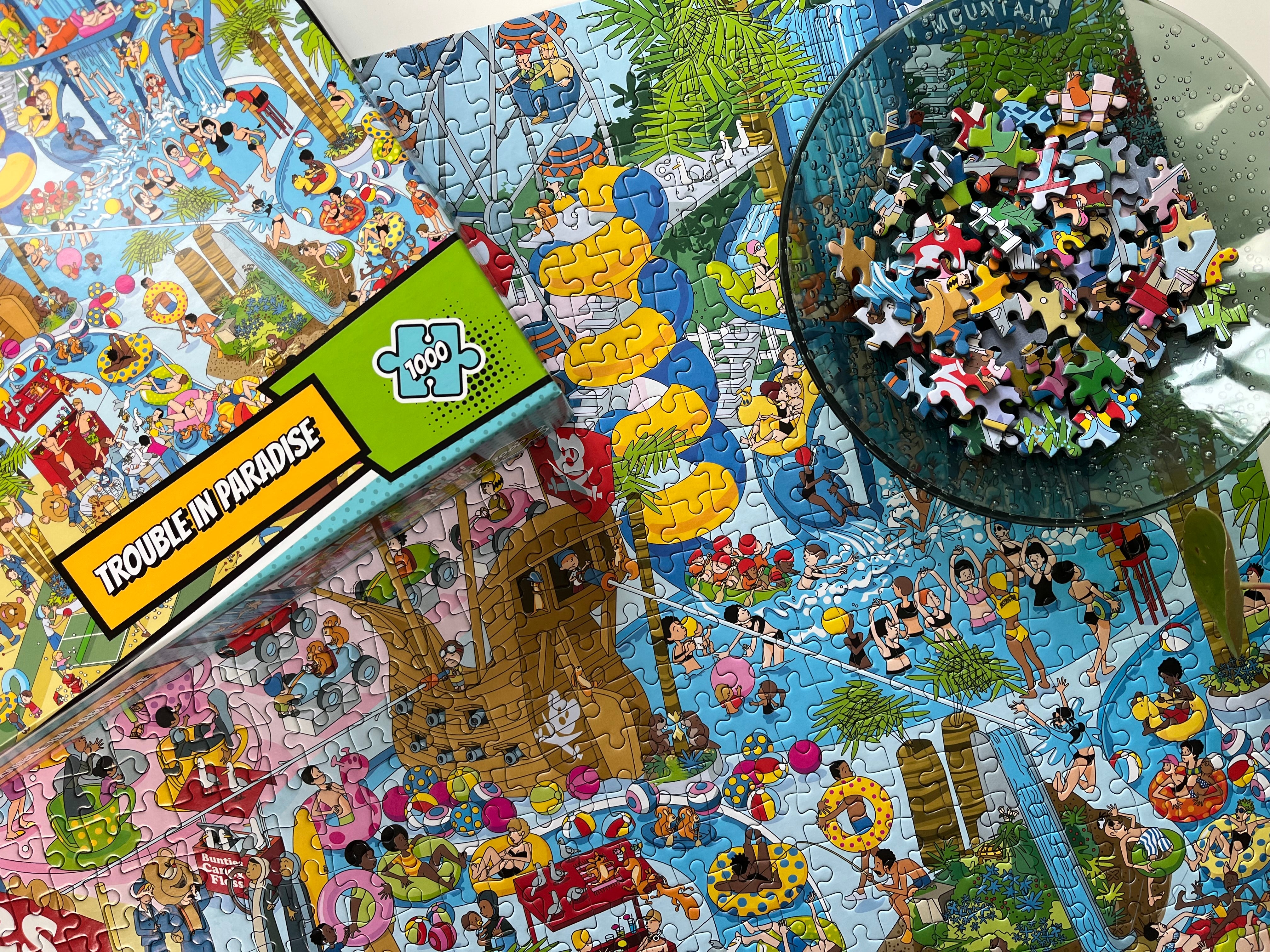 Jigsaw puzzle with a colorful design, partially completed, and a box labeled 'Trouble in Paradise'.