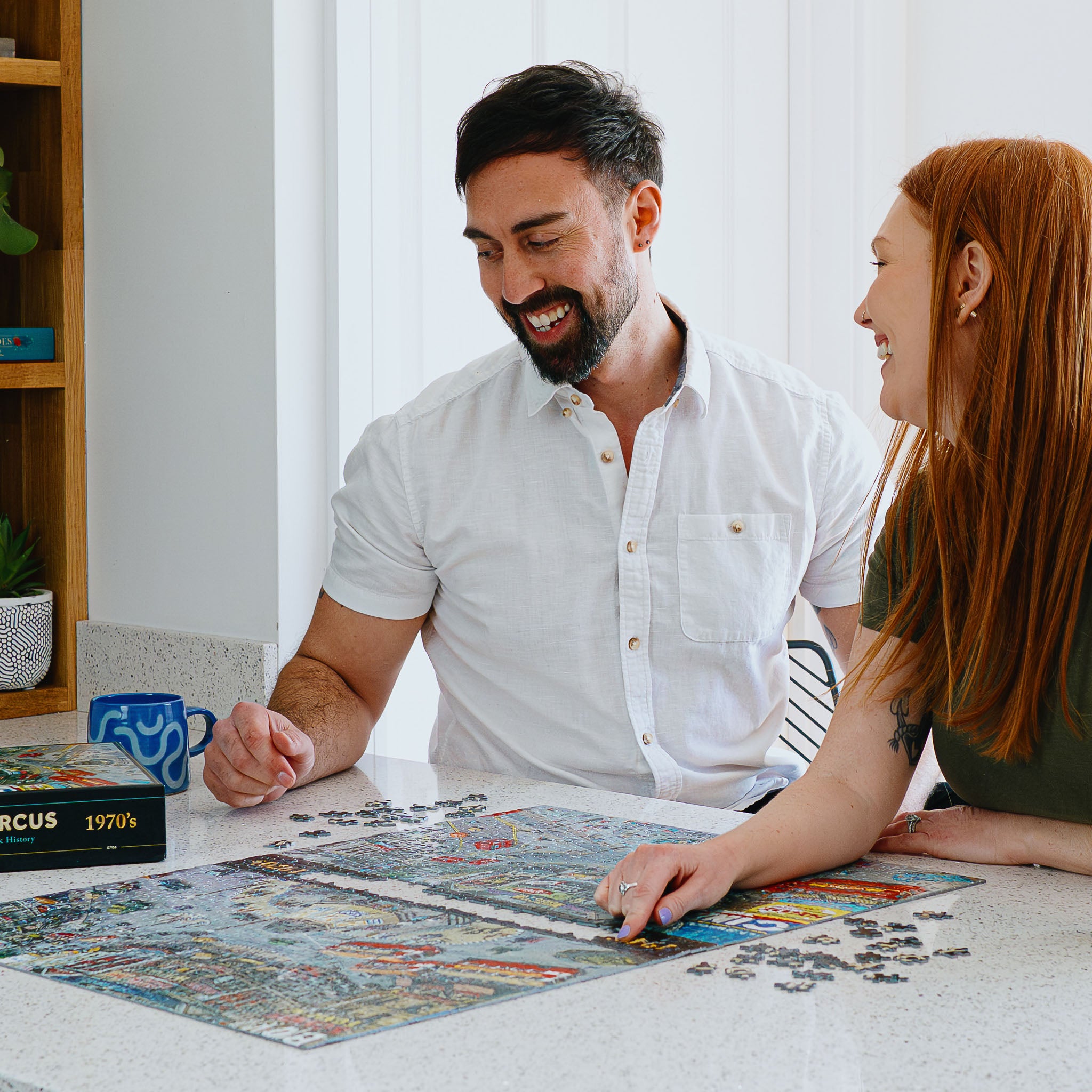 Couple laughing and doing Gibsons puzzle together