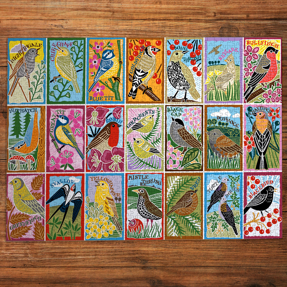 Grid of colorful cards featuring illustrations of birds on a wooden surface