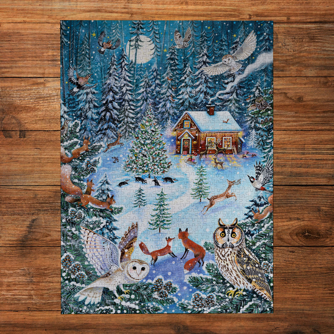 Winter scene with a cabin, animals, and snowy landscape on a wooden surface