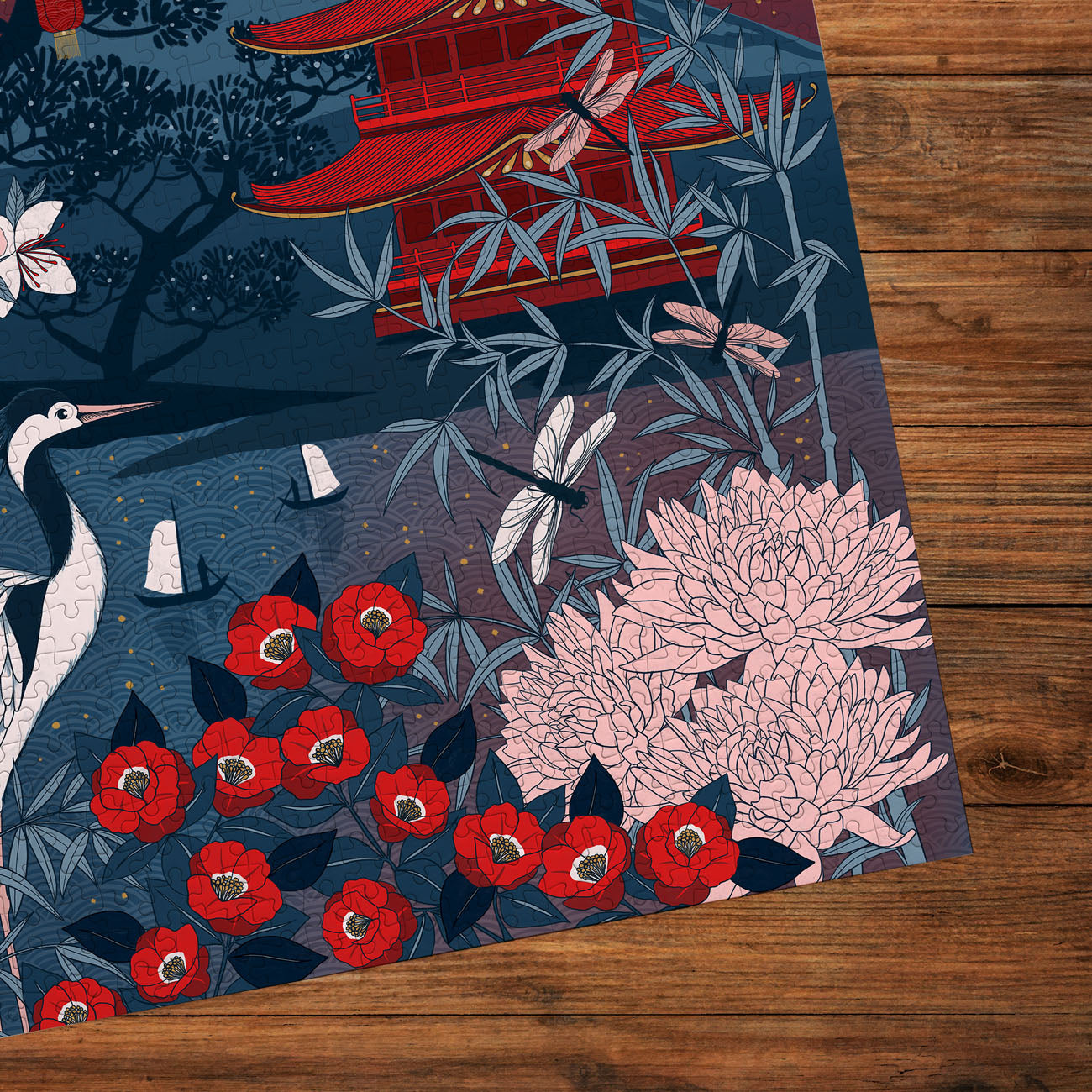 Decorative puzzle with Japanese-inspired design featuring flowers, birds, and a pagoda on a wooden surface.