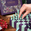 Hand playing a chess set with decorative box in the background