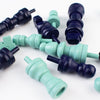 Teal and purple wooden chess pieces on a white background
