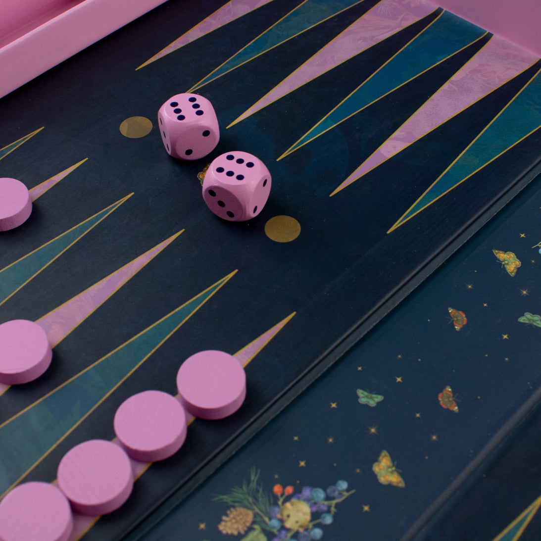 Pink dice and game pieces on a backgammon board with decorative elements.