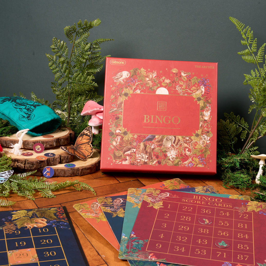 Decorative bingo game set with colorful cards and a bingo box on a wooden surface.