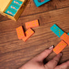 Colorful dominoes on a wooden surface with a hand interacting with them