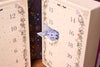 Decorative advent jigsaw calendar with floral patterns and numbered doors.