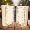 Advent calendar shaped like an open book with decorative pages on a wooden surface.