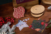 Decorative jigsaw puzzles with floral patterns on a wooden surface with Christmas decorations.