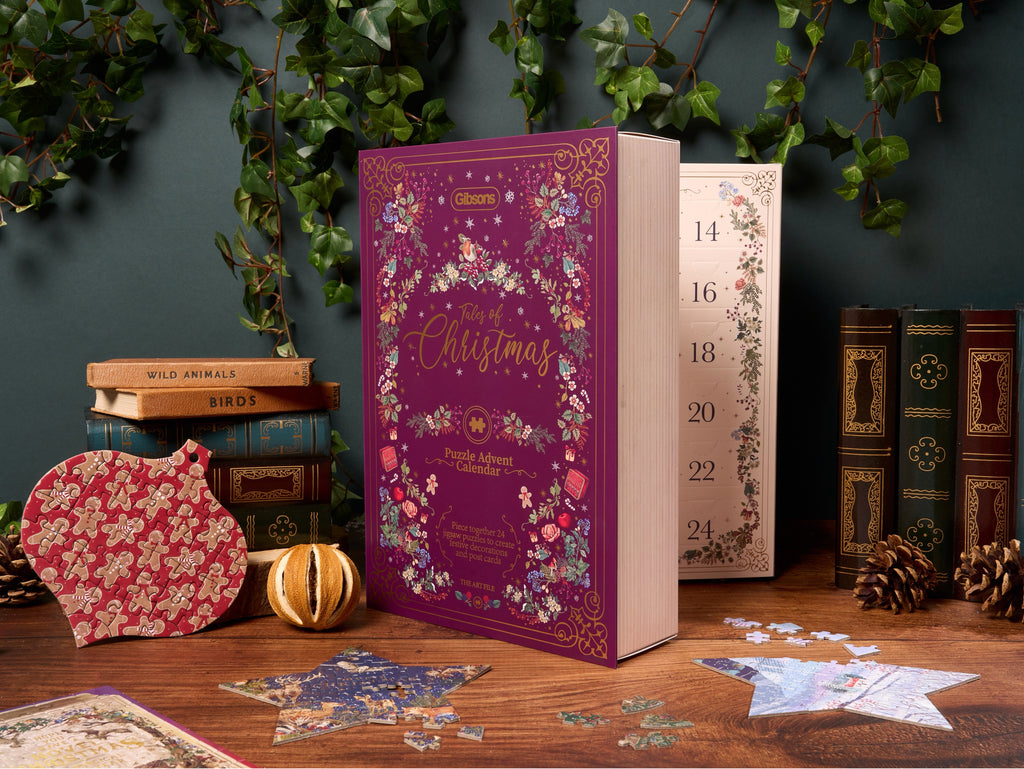 Decorative Christmas Jigsaw advent calendar with purple cover on a wooden surface.