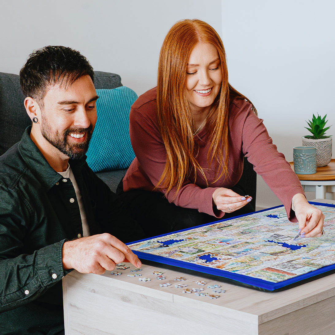 Man and woman playing a board game together in a cozy living room.