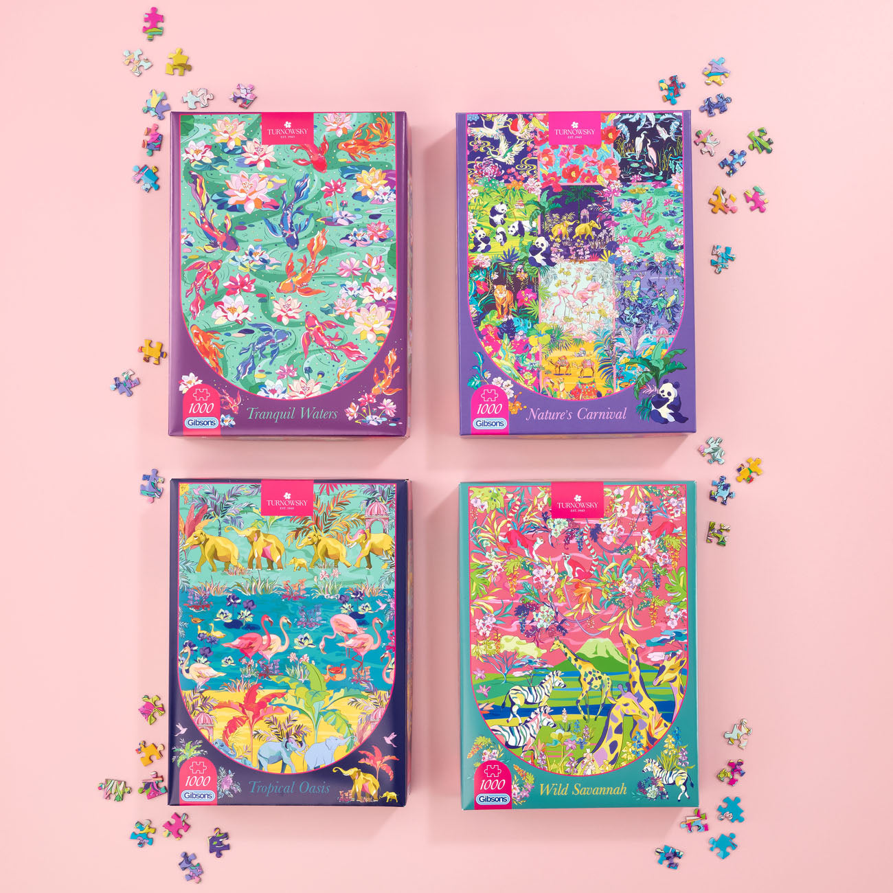 Four colorful jigsaw puzzle boxes arranged in a 2x2 grid on a light pink background, with loose puzzle pieces scattered around them. The boxes feature vibrant illustrated covers with animals and nature scenes, and each has a small red label at the top.