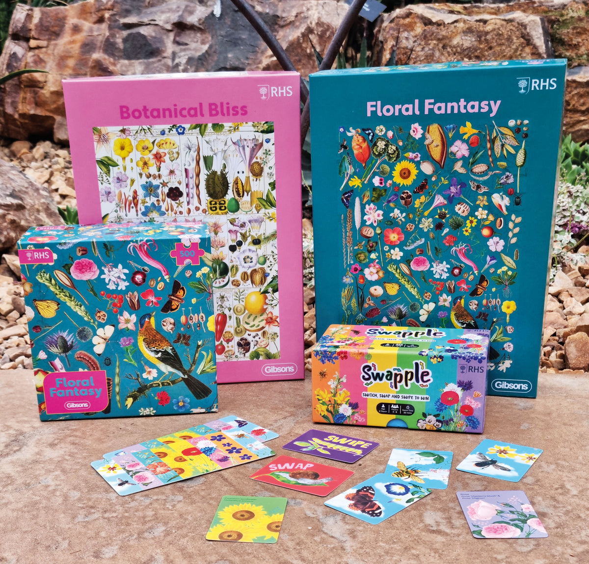 Colourful botanical-themed products including boxes and cards on a natural stone background