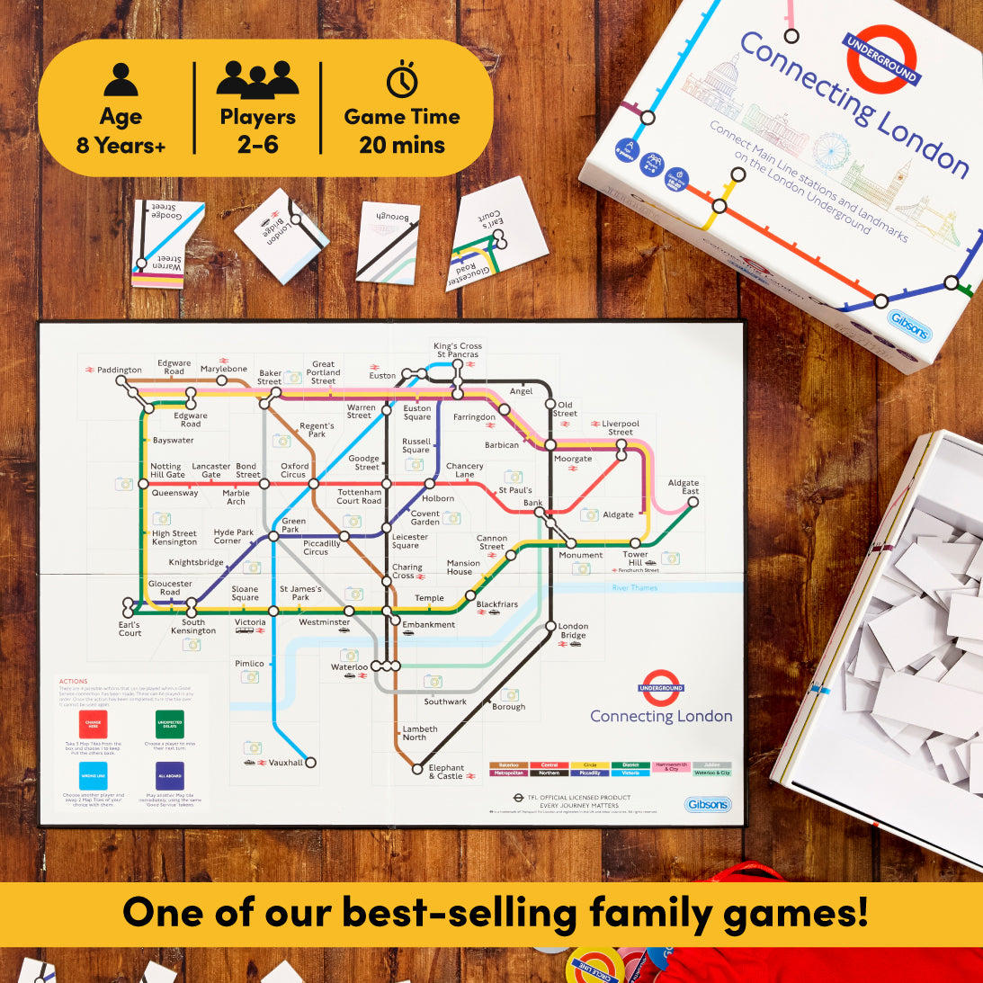 Connecting London family board game set displayed on a wooden tabletop, including the game box, printed game board, cards, and white pieces. A yellow banner at the top shows age, players, and game time, and another yellow banner at the bottom reads 'One of our best-selling family games!'.
