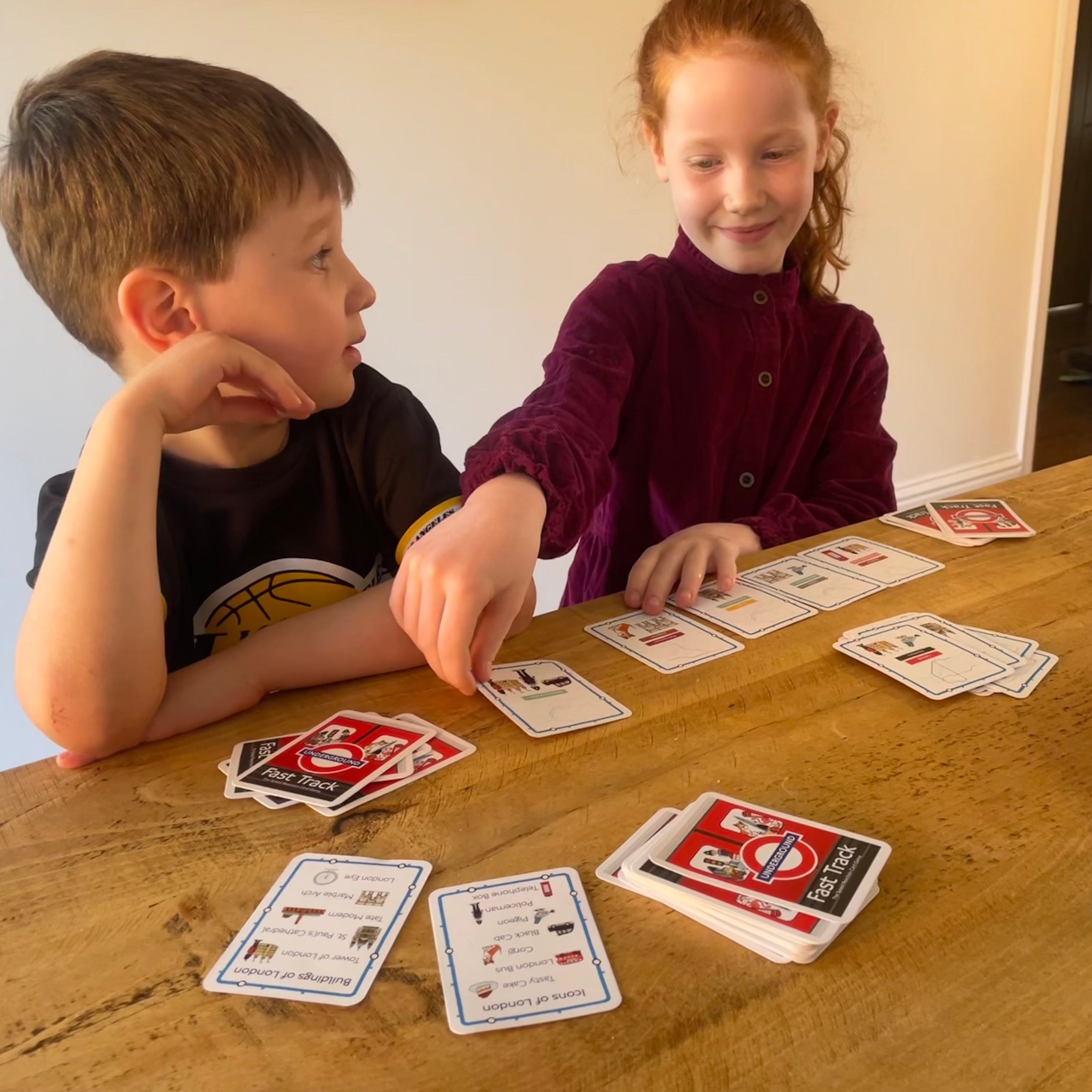 2 children playing fast track TFL kids game by Gibsons 